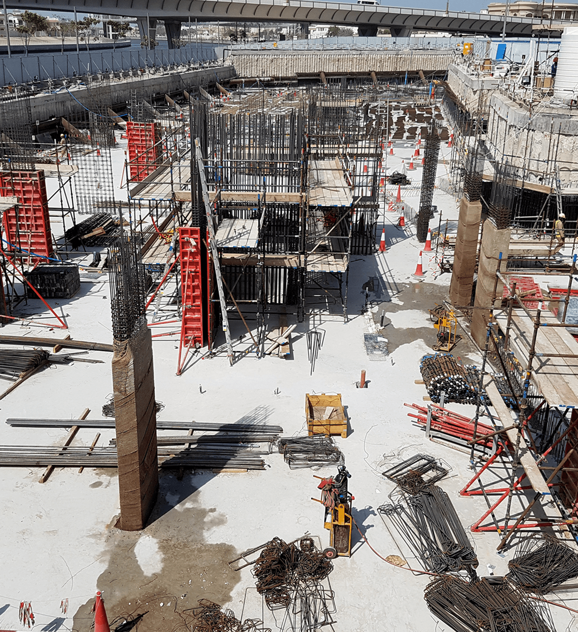 Construction site with workers and concrete framework in progress.