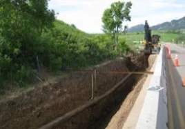 Digging trench beside road and greenery