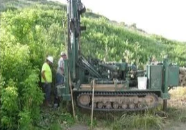 Workers operating drilling machinery outdoors